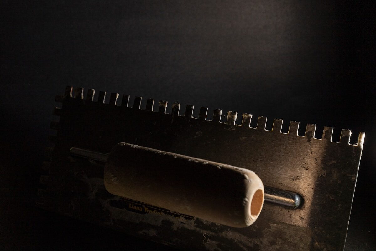 A trowel working over a freshly coated wall surface